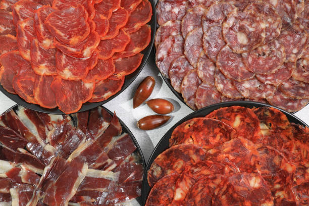 several servings of iberian sausages: iberian ham, loin, chorizo and 100% acorn-fed salchichón - bologna imagens e fotografias de stock