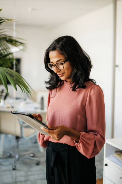 istock Successful business woman on her tablet in a bright office 1314214637