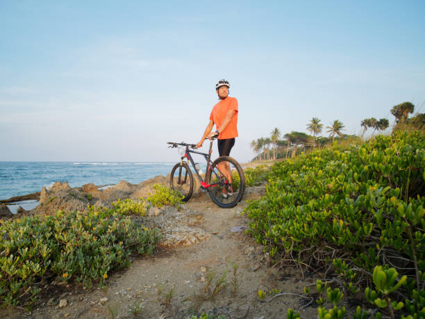 istock Mountain biker stands at ocean shore with bicycle. 1314215053