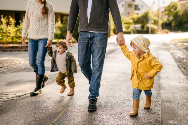 deux petits frères sur une promenade avec leurs parents - petite ville photos et images de collection