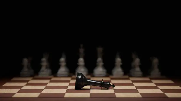 Fallen black chess king in front of the white opposing army. Defeat, failure, coup concept. Digital 3D rendering.