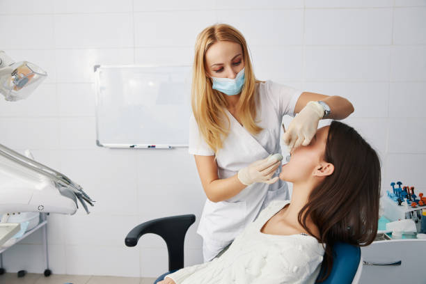istock Dentist putting putty stone into patient mouth for dental impression 1314217543