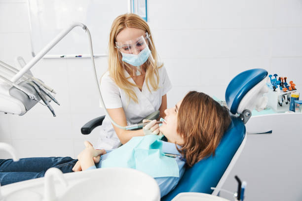 istock Orthodontist drilling boy side teeth with handpiece 1314217575