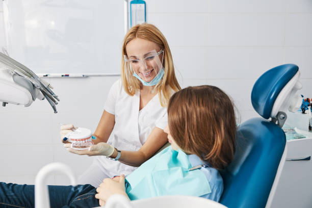 istock Loving female dentist giving boy a lesson about teeth brushing 1314217657