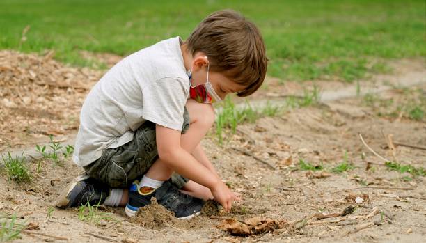 istock Little boy wearing a protective face mask playing at the schoolyard 1314217725