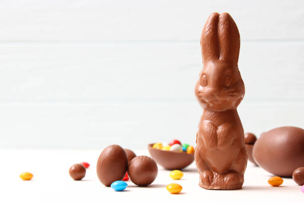 Easter composition with chocolate eggs and chocolate rabbit on wooden background