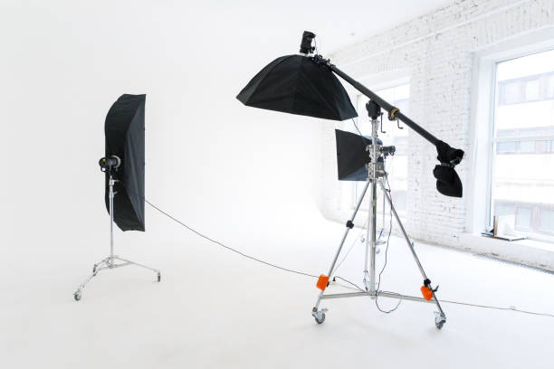istock Empty photo studio with lighting equipment. Photographer workplace interior with professional tool set gear. Flash light white background scenes ready for studio shooting. Modern photographer studio 1314219669