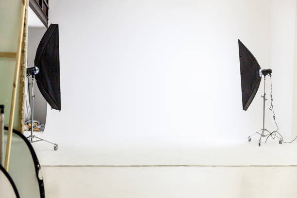 istock Empty photo studio with lighting equipment. Photographer workplace interior with professional tool set gear. Flash light white background scenes ready for studio shooting. Modern photographer studio 1314219744