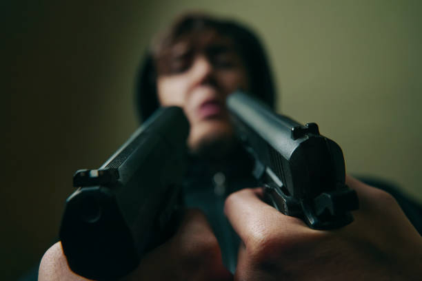 istock Close-up of two guns pointed at guy. 1314220474
