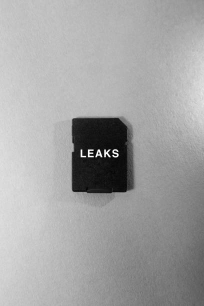 istock Leaks inscription on a small black memory card which lies on a table, vertical shot. Leaks and compromising information concept 1314220869