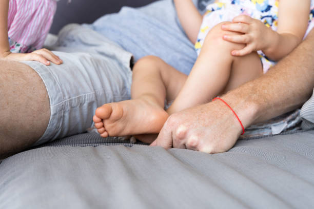 istock Anonymous father sitting on sofa with little daughters 1314228068