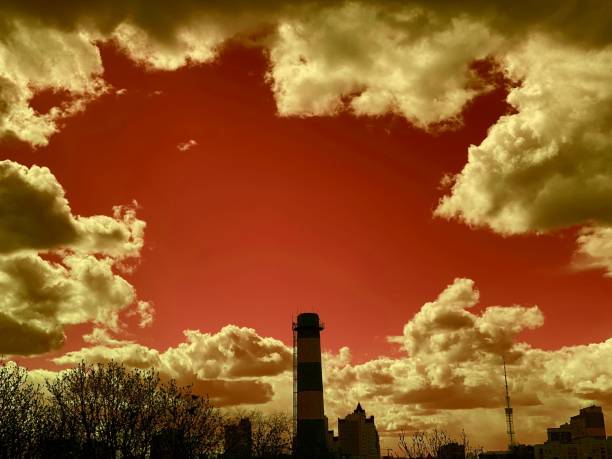 paysage urbain industriel avec des tuyaux et des bâtiments contre un ciel cramoisi. coucher du soleil dramatique en ville. - factory night skyline sky photos et images de collection