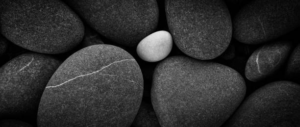 istock Dark black abstract smooth round pebbles sea texture background 1314229772