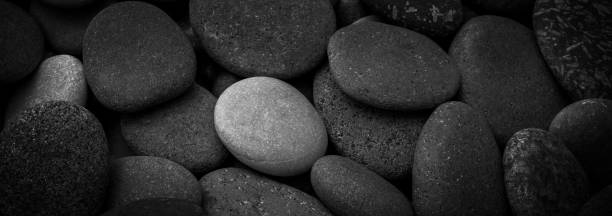 istock Dark black abstract smooth round pebbles sea texture background 1314229825