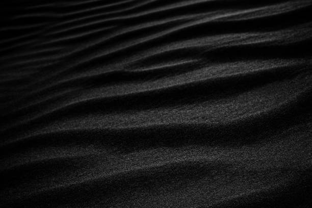 istock Black Sand dune. Black Sand beach macro photography. Background, texture, wave pattern of oceanic sand on the beach, black. Texture of beach sand. Black beach. 1314229916