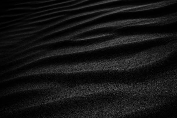 Black Sand dune. Black Sand beach macro photography. Background, texture, wave pattern of oceanic sand on the beach, black. Texture of beach sand. Black beach. Black Sand dune. Black Sand beach macro photography. Background, texture, wave pattern of oceanic sand on the beach, black. Texture of beach sand. Black beach. black sand stock pictures, royalty-free photos & images