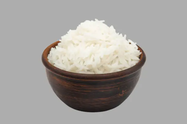 boiled white rice in simple clay bowl isolated on gray background
