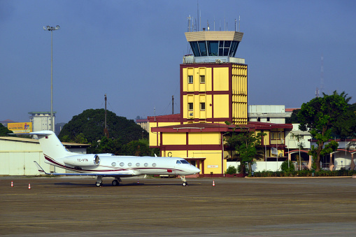 Conakry, Guinea: Conakry International Airport aka Gbessia International Airport - yellow control tower and parked Gulfstream G450 twin jet.