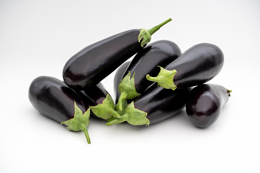 Organic eggplants on white background