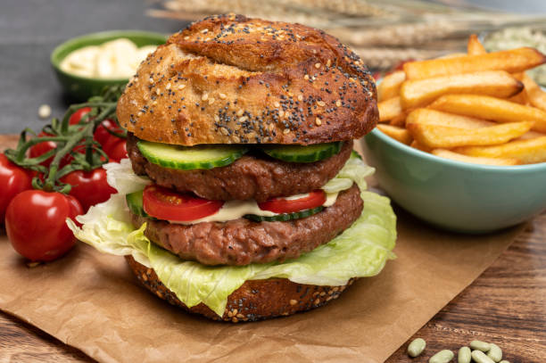 istock Tasty vegetarian vegan lunch with double decker hamburger made from plant based soya beans burger, organic bun with seeds and fresh vegetables and french fried potatoes 1314233784
