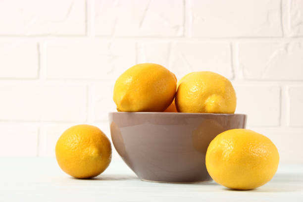 istock lemons and green leaves on a colored background. 1314234725