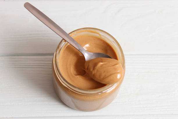istock creamy peanut butter and peanuts beans on wooden background top view 1314235921