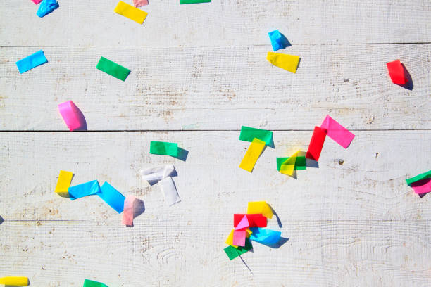 multicolored confetti on the white painted wooden floor or table background