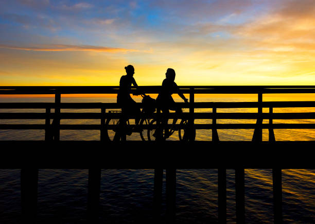 istock two young women cycling on bridge at sunset 1314238752