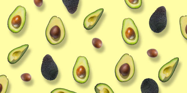 istock Avocado pieces and halves isolated on yellow background. Top view. Flat lay 1314238917
