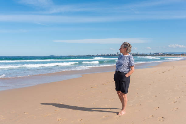 istock Barefoot senior woman looking at ocean 1314242655