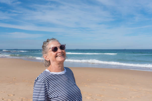 istock Senior woman laughing at beach 1314242735
