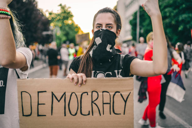 istock Female protester holding placard with text 