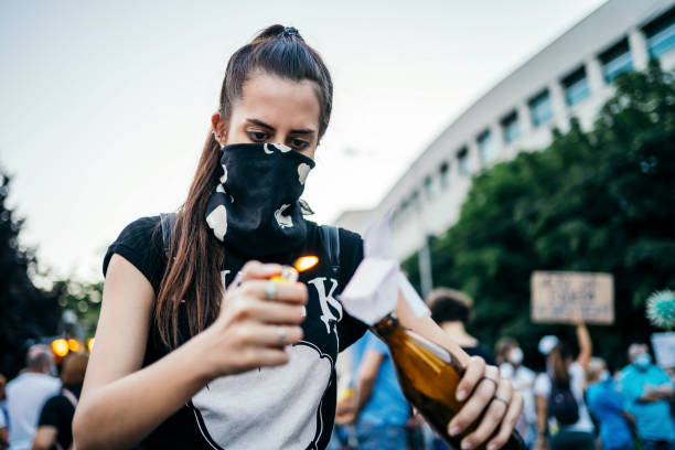istock Female protester lights Molotov cocktail 1314243691