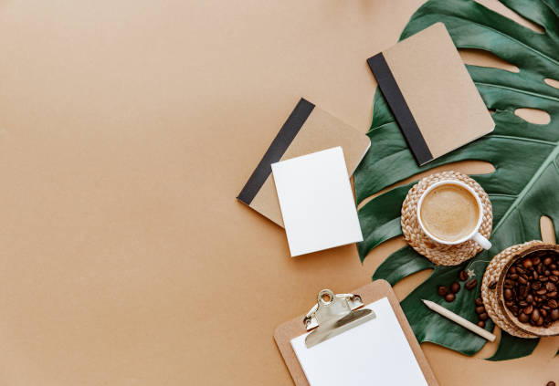 istock A simple trendy office Desk. Coffee cup, monstera leaf, blank card and notebook .Home Office desktop with space copying. Top view, copy space. Minimal concept 1314244507