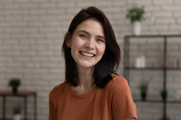 istock Laughing young lady looking at camera enjoy talk by videocall 1314252983