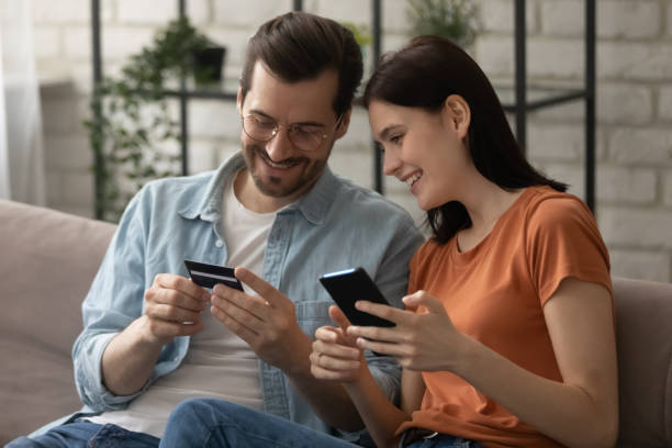istock Happy married couple making payment online using phone credit card 1314253015