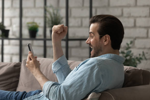 istock Overjoyed millennial man winner shout yes looking at cell screen 1314253016