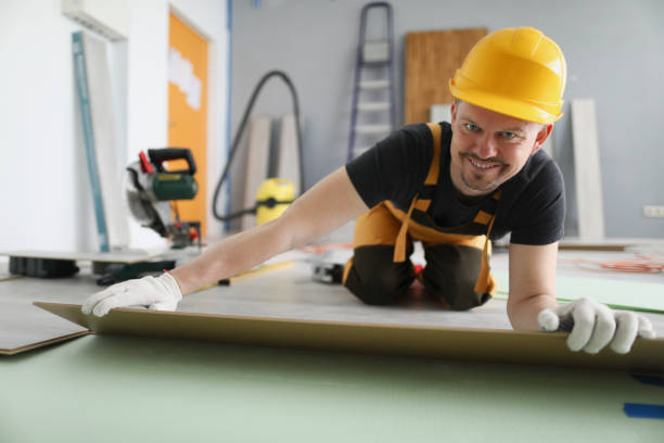 istock Man builder in yellow helmet lying laminate boards on floor 1314253857