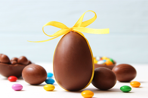 Easter composition with chocolate eggs and chocolate rabbit on wooden background, place for text. easter sweets. High quality photo