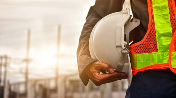 technicien retenant le fond blanc de lumière du soleil de casque de sécurité de chapeau - work safe photos et images de collection