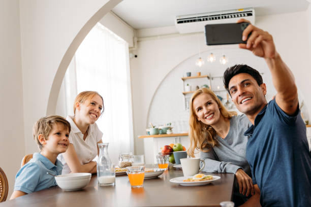 istock Family group taking a photo with smart phone while eating breakfast 1314260379