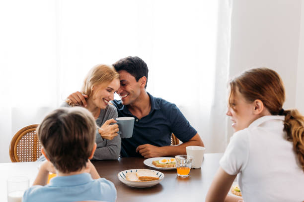 istock Couple embracing while having breakfast with kids 1314260392