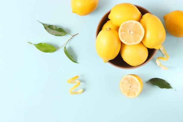 istock lemons and green leaves on a colored background. 1314264174