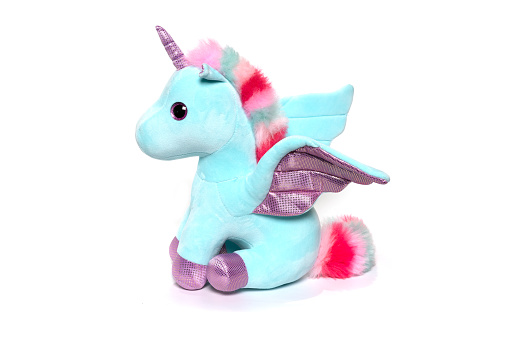 Unicorn plush toy sitting. Isolated on white background