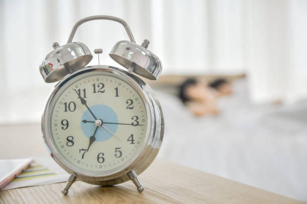 istock Clock time wake up on table in bedroom 1314269265