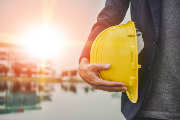 istock Businessman holding hard hat on site construction building estate 1314269332