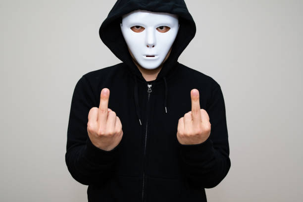 istock Hacker with blank mask showing his middle fingers 1314270223
