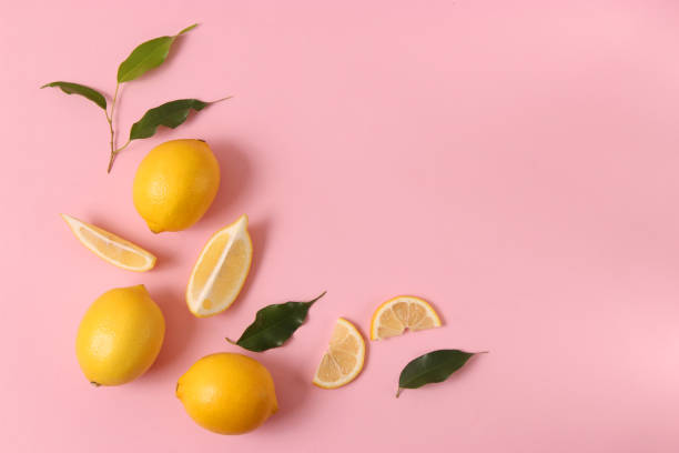 istock lemons and green leaves on a colored background. 1314273104