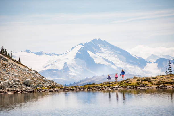 Single mother hiking with daughters in moutnains. stock photo