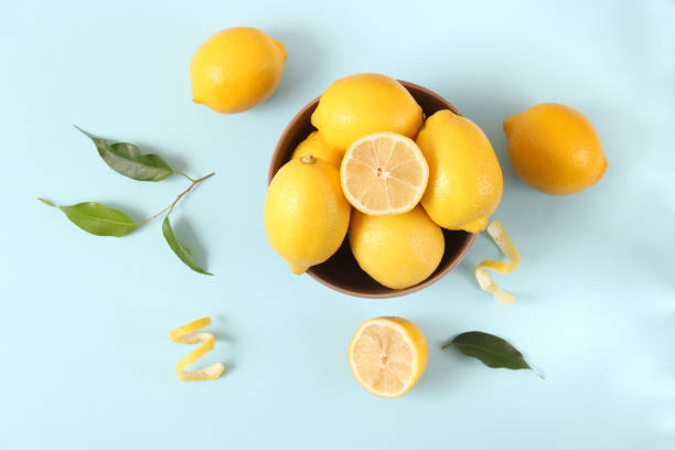 istock lemons and green leaves on a colored background. 1314274779